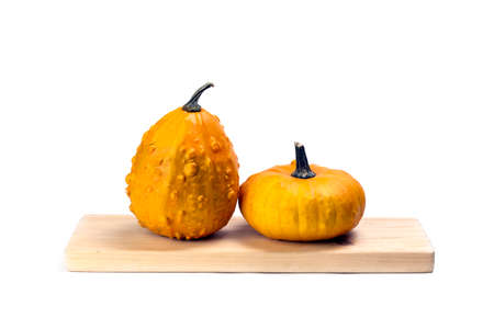 Two different shape pumpkins on wooden plank isolated on white background.の写真素材
