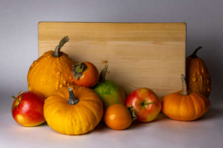 Autumn harvest fruits and wooden signboard isolated on white background. Apples, pumpkin, and kinglet.の写真素材