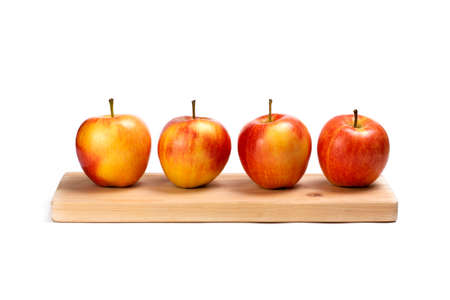 Apples on wooden plank isolated on white background. Red juicy apples row.の写真素材