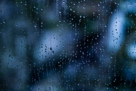 Rain drops on window glass. Sadly, atmosphere background.の写真素材