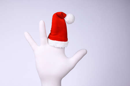 White hand with Santa Claus heat on finger. Christmas and New Year holidays concept.の写真素材