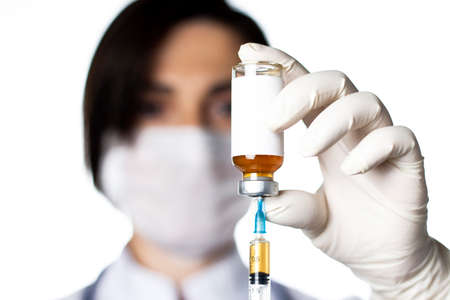 Ampoule and syringe in hands of doctor. Vaccinations or cosmetology concept.の写真素材