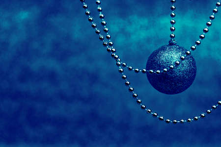 Classic blue Christmas and New Year decoration. Christmas tree balls and beads on trendy blue blurred background.の写真素材