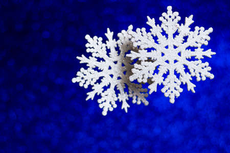 Decorative snowflakes on glitter and shine classic blue background. Christmas and New Year trendy...