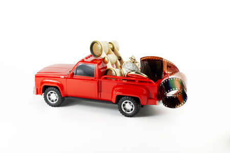 Retro opera glasses, golden pocket watch and kay in red trendy pickup trunk. Toy truck, golden kay,...