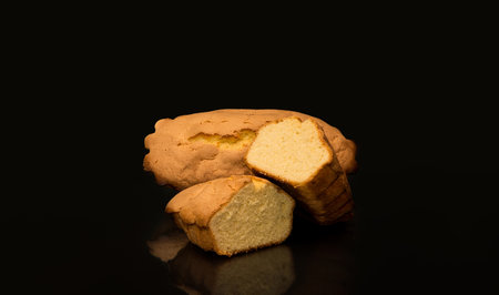 Rebojos, sponge cake from the Spanish city Zamora made by hand with a black background, one whole and the other cut in half.の写真素材
