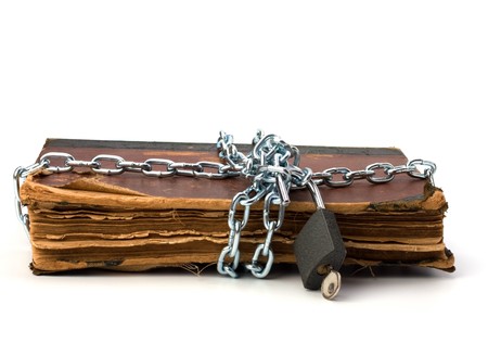 tattered book with chain and padlock isolated on white backgroundの写真素材