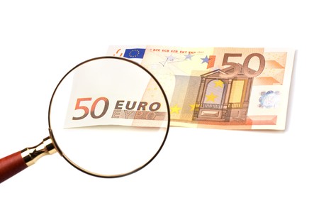 hand magnifier over banknote isolated on white backgroundの写真素材