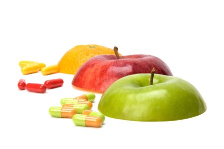 sliced fruits and pills isolated on white backgroundの写真素材
