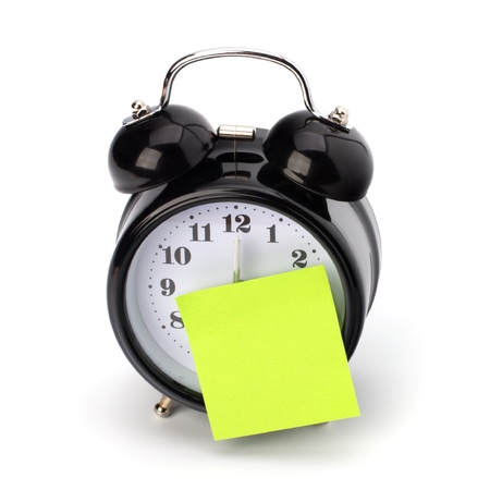 Alarm clock with sticky paper isolated on white backgroundの写真素材