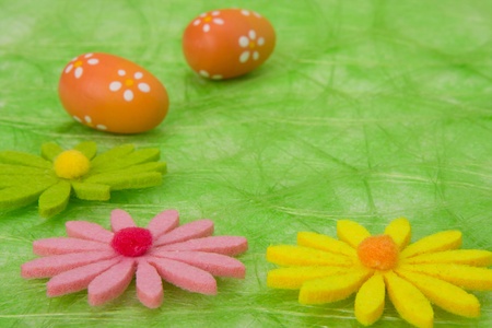 Easter background. Easter eggs and flowers on green sisal background, selective DOF.