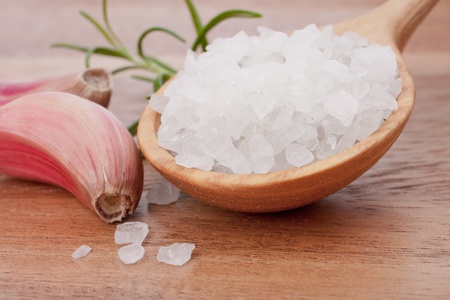 Fresh herbs and salt spoon on vintage wooden background. Shallow focus.の写真素材