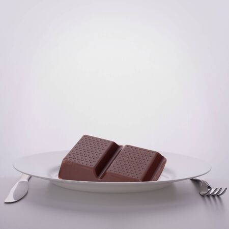 Chocolate bars stack on plate. Unhealthy eating concept.の写真素材