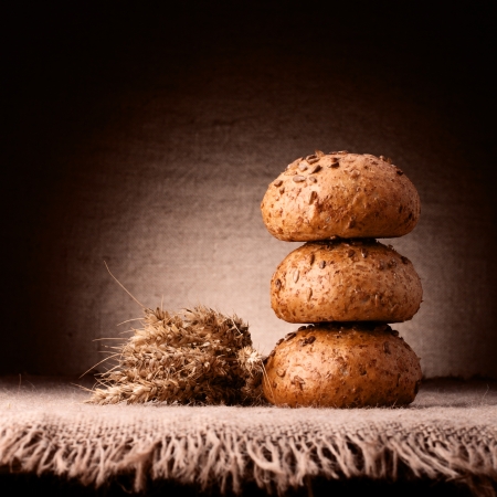 Assortment of breads and ears bunch still life on rustic backgroundの写真素材