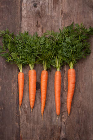 fresh carrot bunch on grungy wooden backgroundの写真素材