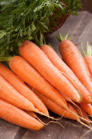 fresh carrot bunch on grungy wooden backgroundの写真素材