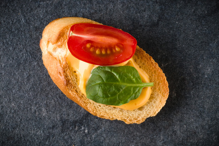 Open faced sandwich canape or crostini on dark stone background closeup. Top view. Vegetarian tartarine.の写真素材