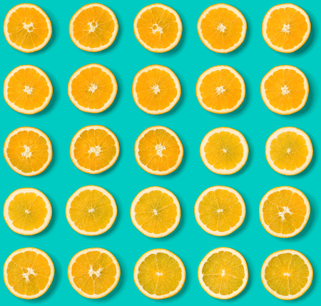 Seamless pattern of orange fruit slices on blue background. Flat lay, top view. Food background. . ...
