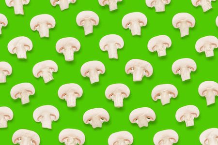 Food pattern of champignon slices on green background. Flat lay, top view. Mushroom background.の写真素材