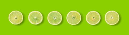 Fruit pattern of lemon slices on green  background. Flat lay, top view. Banner, seamless pattern, creative summer food concept.の写真素材