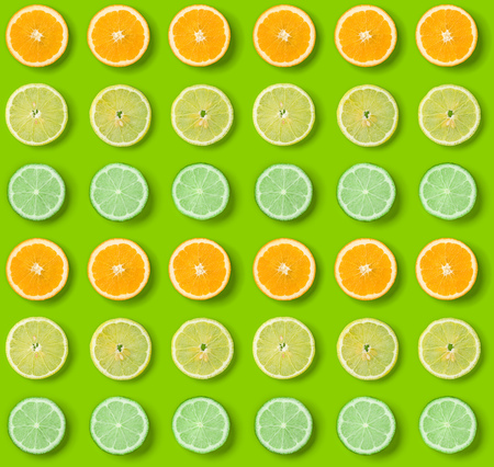 Citrus Fruits pattern on green background. Orange, Lime, Lemon slices background. Flat lay, top...