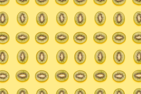 Kiwi slices pattern on green background. Food background. Fruit pattern.  Pop art design, creative summer concept.の写真素材