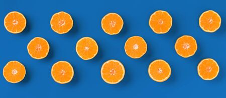 Fruit pattern of fresh orange tangerine or mandarin on blue background. Flat lay, top view. Pop art...