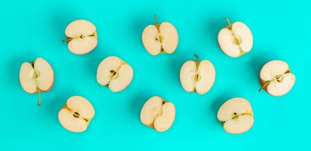 Fruit pattern of apple halves on blue background. Flat lay, top view. Food background..  Pop art design, creative summer concept.の写真素材