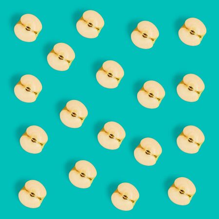 Fruit pattern on blue background. Apple halves geometrical layout. Flat lay, top view. Food...