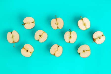 Fruit pattern of apple halves on blue background. Flat lay, top view. Food background.の写真素材