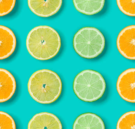 Citrus Fruit pattern on blue background. Orange, Lime, Lemon slices background. Flat lay, top view.の写真素材