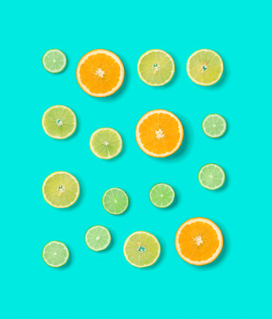 Creative layout made of colorful tropical fruits isolated on blue background. Minimal summer exotic concept. Pop art, flat lay, top view. Orange, Lime, Lemon slices background.の写真素材