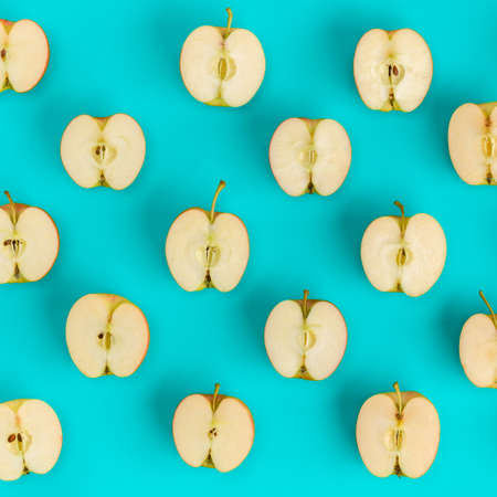 Fruit pattern of apple halves on blue background. Flat lay, top view. Food background.の写真素材