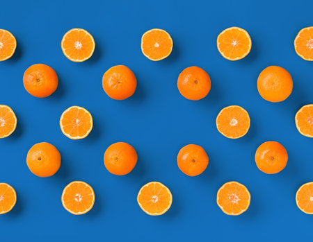 Fruit pattern of fresh orange tangerine or mandarin on blue background. Flat lay, top view. Pop art design, creative summer concept. Citrus in minimal style.の写真素材