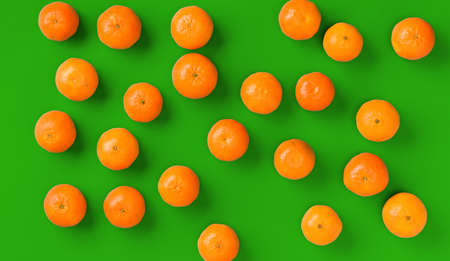 Fruit pattern of fresh orange tangerine or mandarin on green background. Flat lay, top view. Pop art design, creative summer concept. Citrus in minimal style.の写真素材