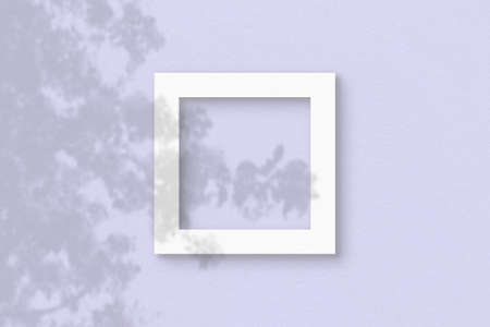 The square sheet of white textured paper on the lilac wall background. Mockup with an overlay of plant shadows. Natural light casts shadows from the leaves of an exotic plant. Flat lay, top view.の写真素材
