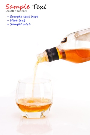 Pouring the brand to a glass on white backgroundの写真素材