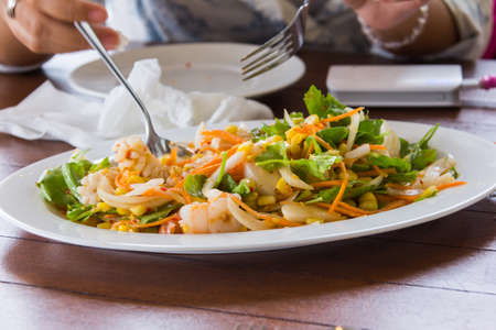 delicious spicy seafood salad on white dish in resterantの写真素材