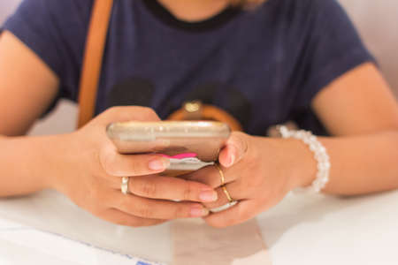 lady hands hold smartphone in restaurant