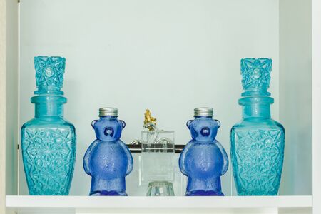 beautiful blue bear glass with green jar in white shelf