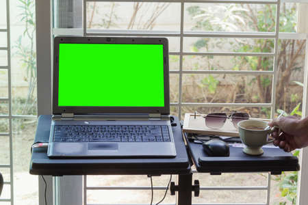 blank screen monitor of laptop with hot coffee on tableのeditorial素材