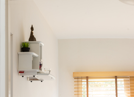 buddha statue on white shelf hang with wallの写真素材