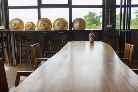 iced blueberry smoothie cup on wood table with hat thai style