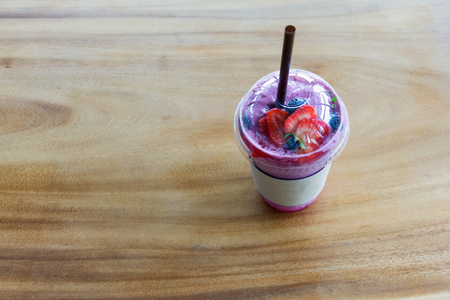 iced blueberry smoothie cup on wood table with hat thai styleの写真素材