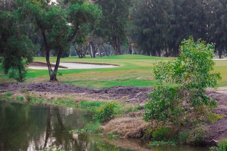 golf course with lush grass and the reflection of the trees in the pool makes it a beautiful view to play sportsの写真素材