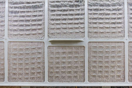 close up on air conditioner filter is very dirty after remove from unit wait clean put on floor