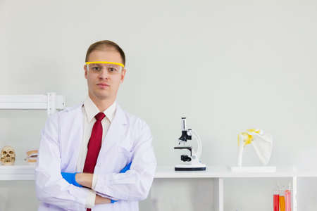 Male scientist wearing blue safety glasses and glove isolated with white backgroundの写真素材