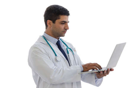 male doctor puts a stethoscope on his neck and holding laptop look to screen monitor isolated with white backgroundの写真素材