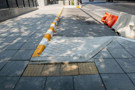 Wheelchair ramps and blind sidewalks on road for in-out to BTS station in city