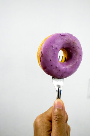 doughnut was fork stab isolated with whith backgroundの写真素材